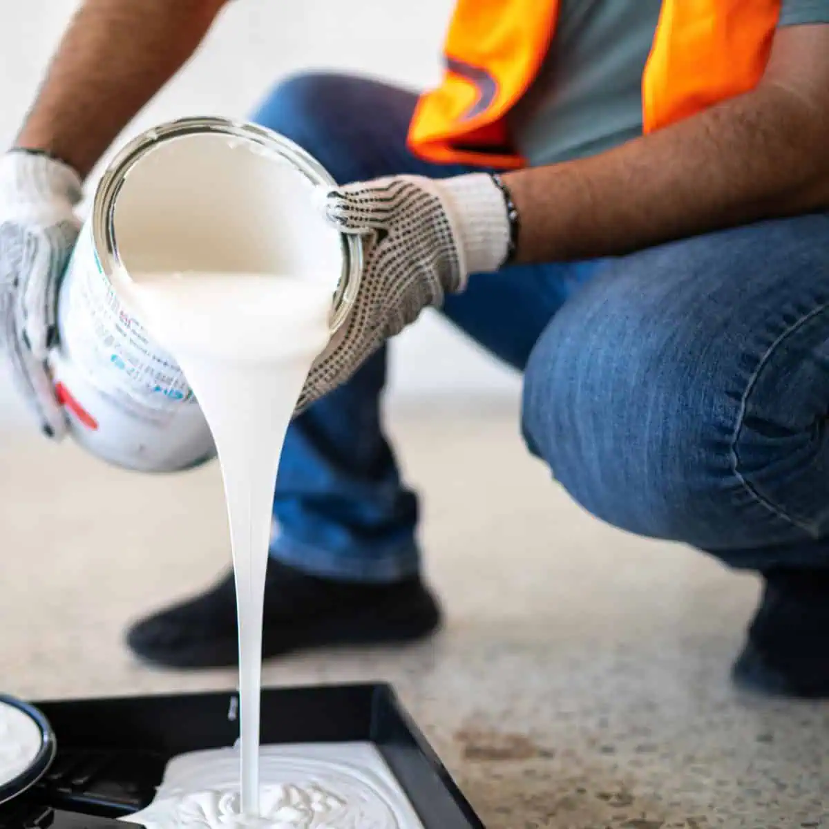 Painter pouring white paint