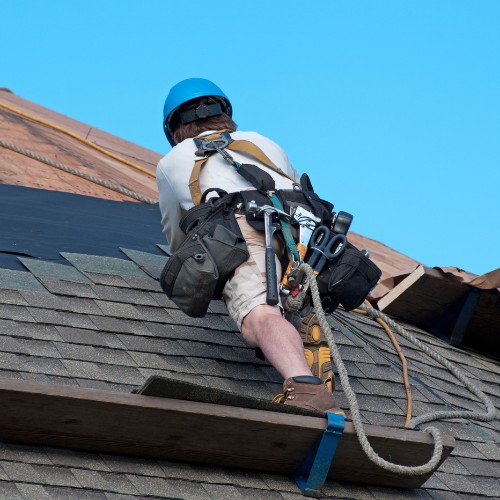 Roofing contractor installing shingles